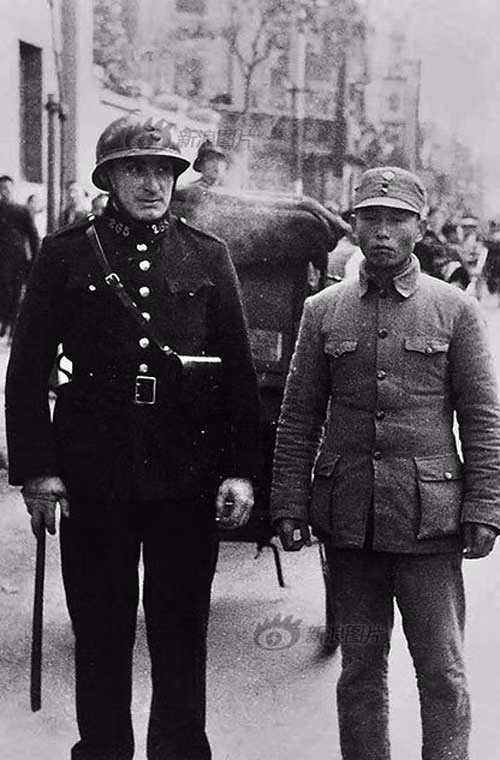 Trong quá trình lính Trung Quốc trở lại vào tô giới của Pháp, một binh sĩ Trung Quốc và một người lính Pháp chụp ảnh lưu niệm.