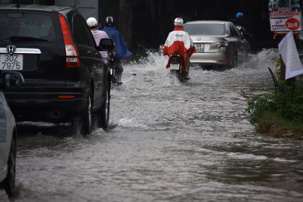 Trong khi đó, tại nhiều điểm đen về ngập úng, người dân Hà Nội vẫn phải di chuyển như bơi sông trên đường phố. Ảnh: Minh Bái.