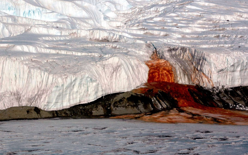 Thác Máu (Nam Cực): Vết nứt từ sông băng Taylor trong thung lũng khô McMurdo, Nam Cực, xuất hiện dòng chảy đỏ như máu hay còn gọi là thác Máu. Đây cũng là địa danh bí ẩn, gây tò mò với nhiều người. Các nhà khoa học đã xác định màu sắc rùng rợn, kinh dị đến từ nguồn nước mặn giàu sắt của sông băng, bị oxy hóa.