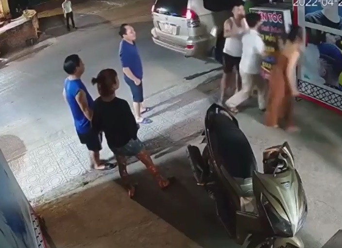 Trước cửa tiệm cắt tóc này, một người mặc quần áo giống công an lôi kéo nam thanh niên trẻ ở quán cắt tóc lên xe ô tô nhưng bị những người có mặt ngăn cản.