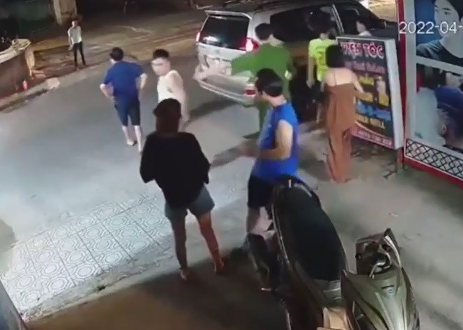 Trong khi đó, người đàn ông mặc áo trắng từ xe bước xuống tát thẳng mặt nam thanh niên mặc áo vàng và một cô gái, sau đó người đàn ông mặc áo trắng tiếp tục đẩy mạnh khiến cô gái này suýt ngã. 