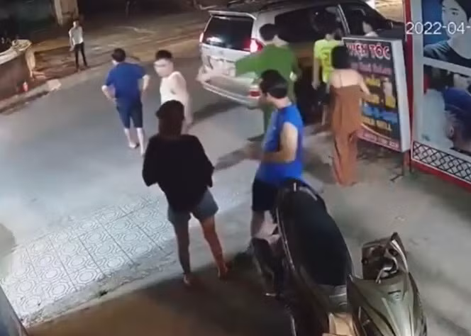 Trong khi đó, người đàn ông mặc áo trắng từ xe bước xuống tát thẳng mặt nam thanh niên mặc áo vàng và một cô gái, sau đó người đàn ông mặc áo trắng tiếp tục đẩy mạnh khiến cô gái này suýt ngã. 