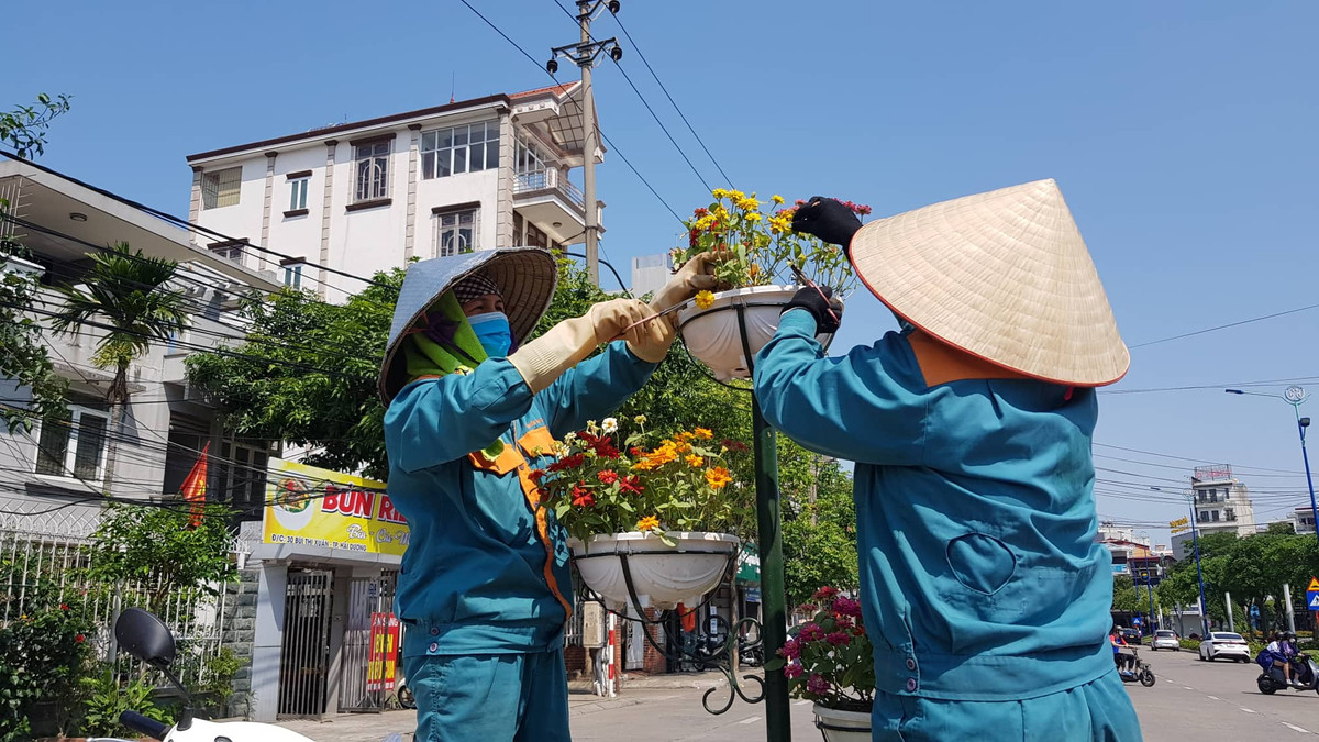 Các công nhân trang trí hoa trên tuyến phố gần Nhà thi đấu tỉnh Hải Dương.