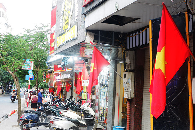 Tuyến phố Cầu Giấy rợp sắc đỏ băng rôn chào mừng. 