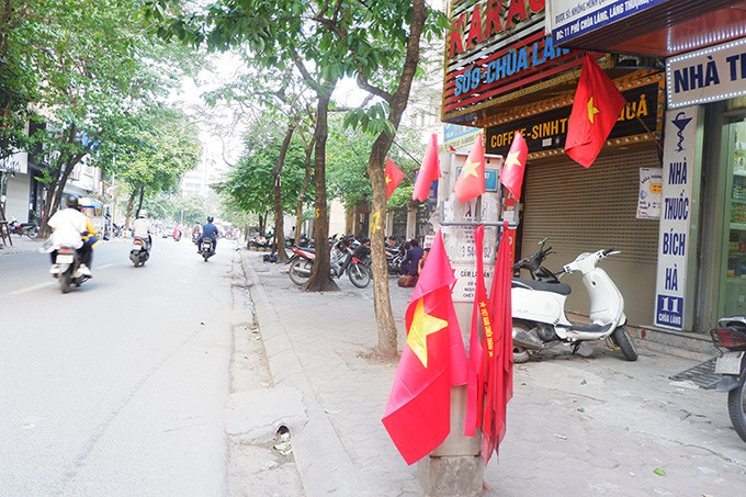 Hình ảnh nhưng lá cờ bay phất phới tại phố Chùa Láng, Hà Nội.