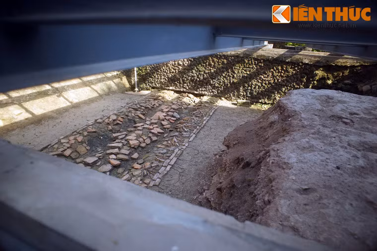 Bên trong hố là những di vật khảo cổ quan trọng. Ở độ sâu 1,2 mét là đường viền đá gia cố chân tường Đoan Môn và sân gạch thời Lê Sơ. Độ sâu 1,9 mét là đoạn đường lát gạch hoa chanh thời Trần. Ngoài ra còn có những viên gạch lát đường thời Lý được dùng lại.