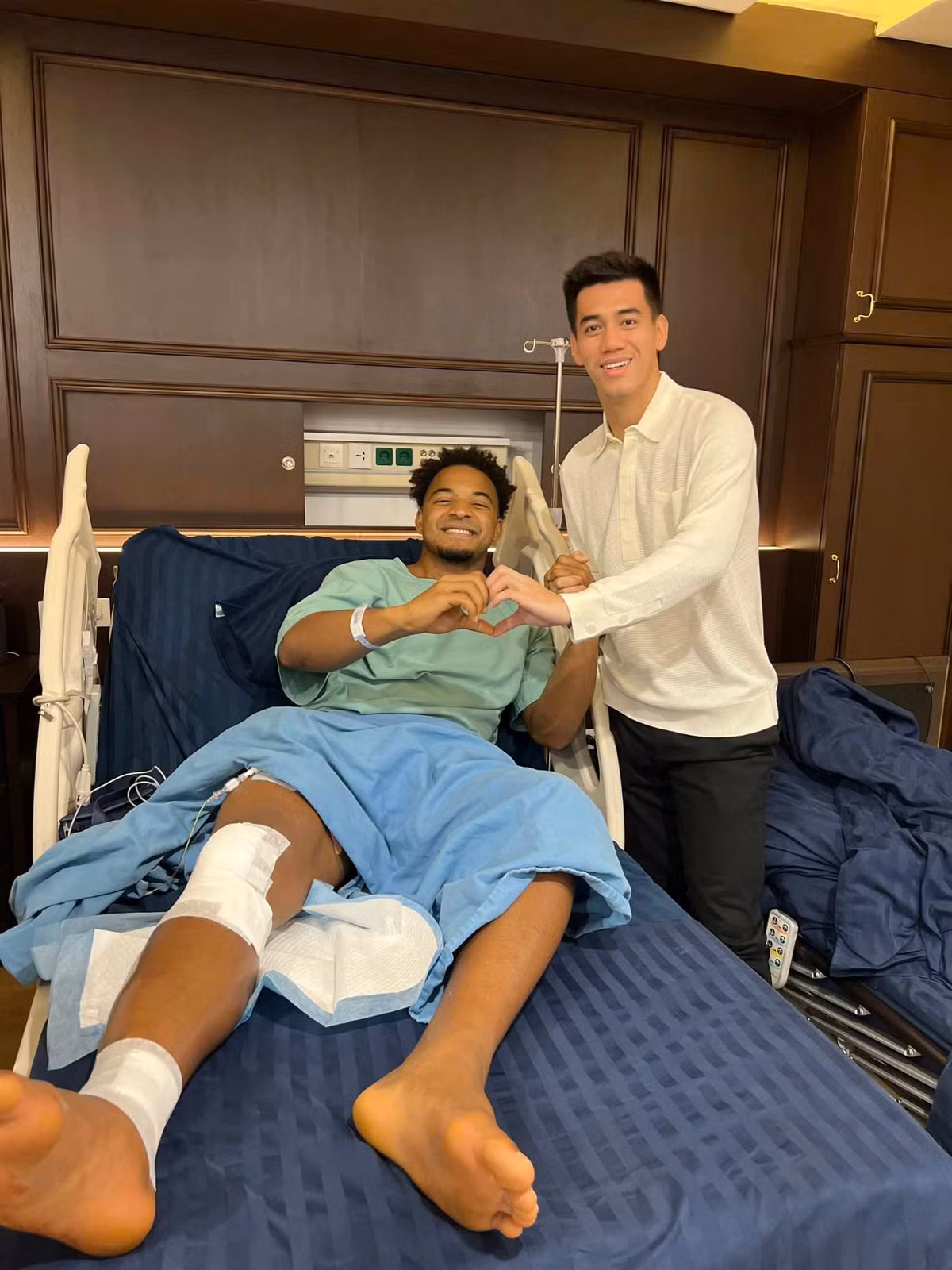 Tiền đạo Nguyễn Tiến Linh cũng vào thăm người đồng đội Nguyễn Xuân Son. Cặp tiền đạo đội tuyển Việt Nam tái hiện màn tạo hình trái tim bằng tay và cười rất tươi.