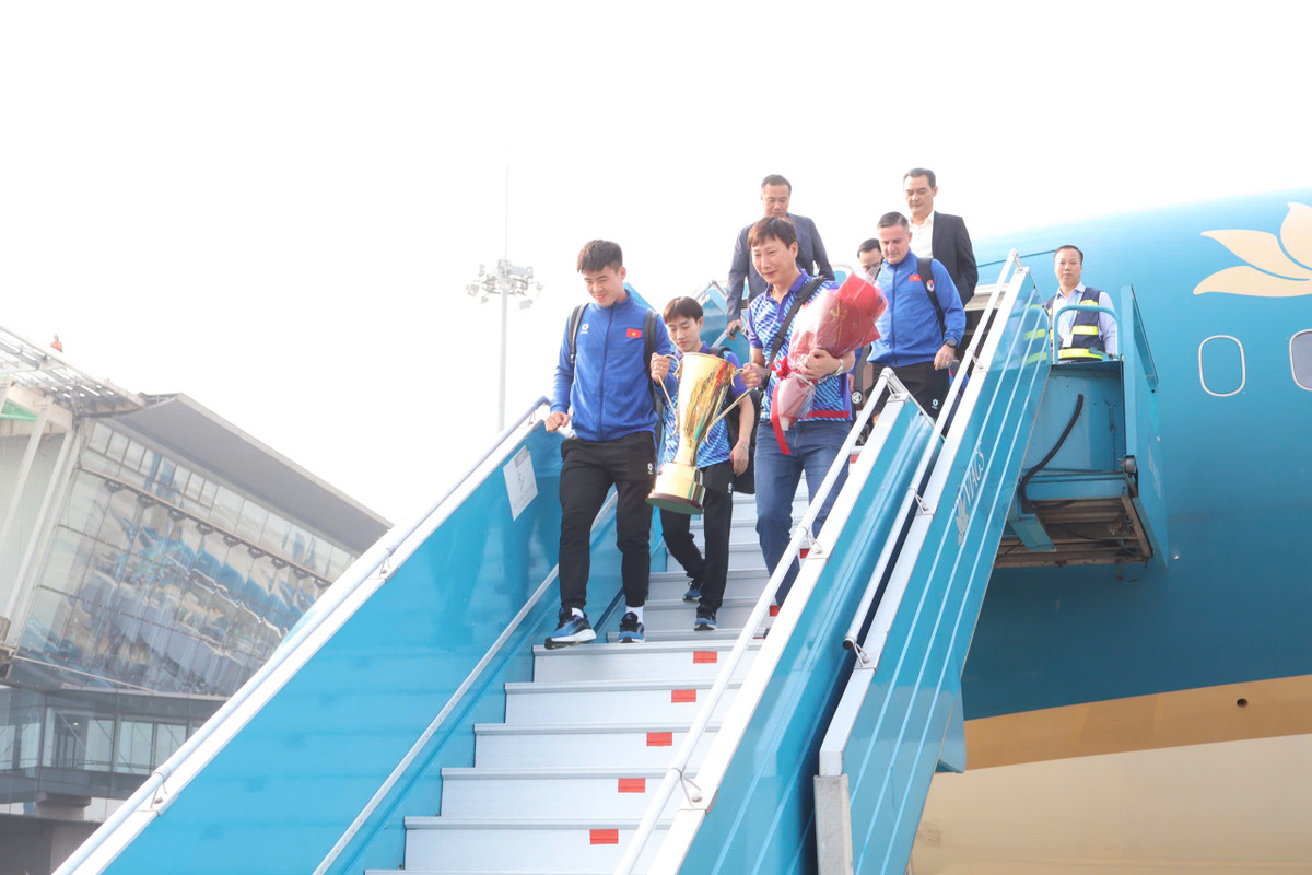 Sau những phút giây chờ đợi, chuyến bay chở đội tuyển Việt Nam đã hạ cánh. Huấn luyện viên Kim Sang-sik và đội trưởng Đỗ Duy Mạnh cầm cúp bước xuống cầu thang.