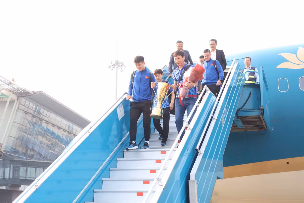 Sau những phút giây chờ đợi, chuyến bay chở đội tuyển Việt Nam đã hạ cánh. Huấn luyện viên Kim Sang-sik và đội trưởng Đỗ Duy Mạnh cầm cúp bước xuống cầu thang.