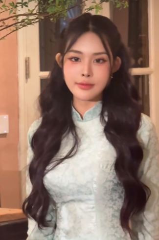 Trong đoạn video, Bích Hạnh diện thiết kế áo dài ôm sát, kết hợp với kiểu tóc sóng lơi nhẹ nhàng cùng lối trang điểm tone hồng cam ngọt ngào, nữ tính.