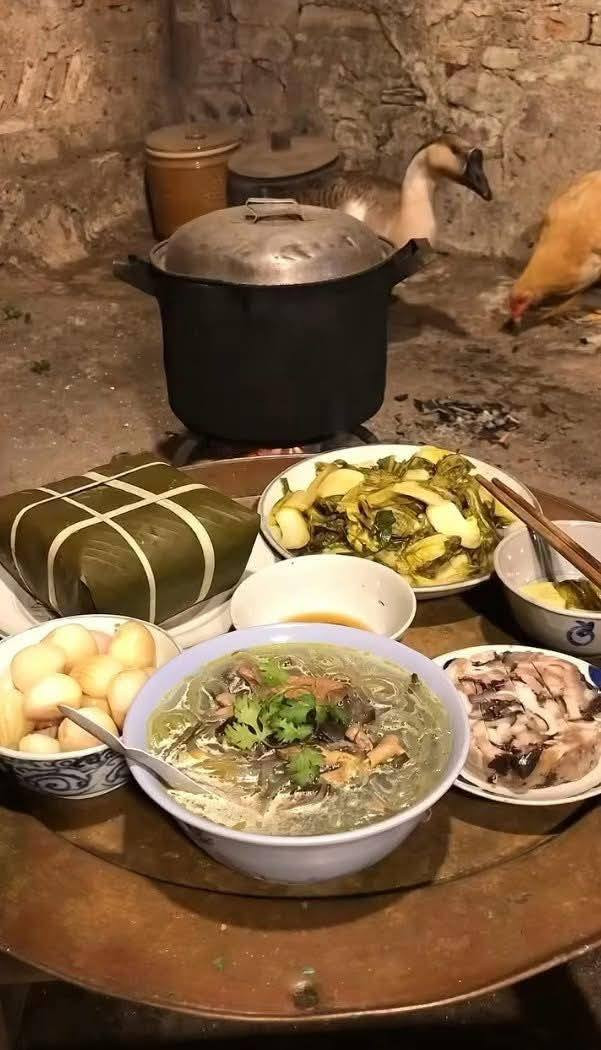 Mâm cơm truyền thống ngày Tết với chiếc bánh chưng xanh, dưa hành, bát canh miến gà, chút chân giò.