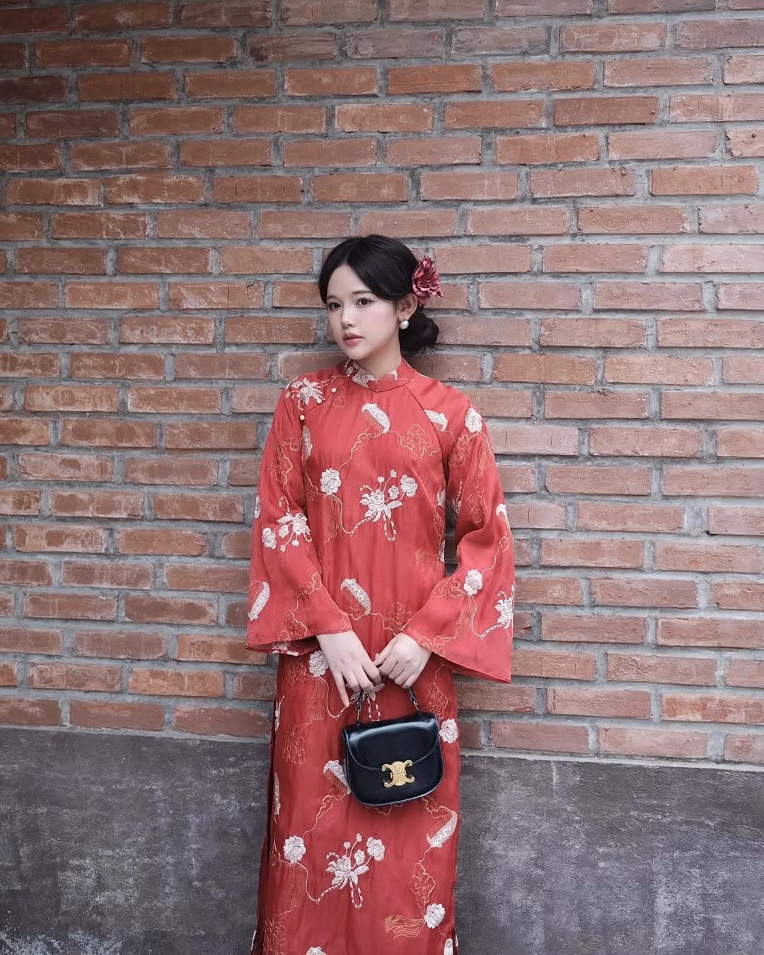 Cô nàng lựa chọn phụ kiện là đóa hoa cài tóc - một món đồ được lòng nhiều chị em trong dịp cuối năm với những bộ ảnh áo dài.