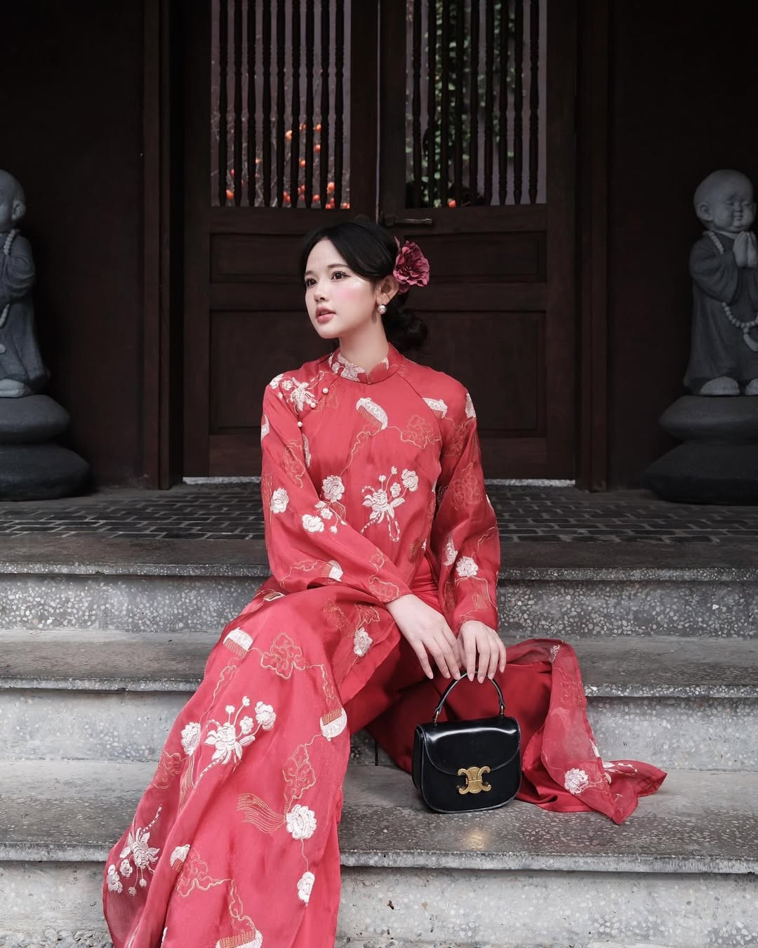 Cũng diện sắc áo dài đỏ xuống phố để chụp ảnh Tết sớm, hot girl Thư Thỏ lựa chọn cho mình một sắc đỏ nhã nhặn hơn, với những họa tiết được thêu lên vải tinh tế, ấn tượng.