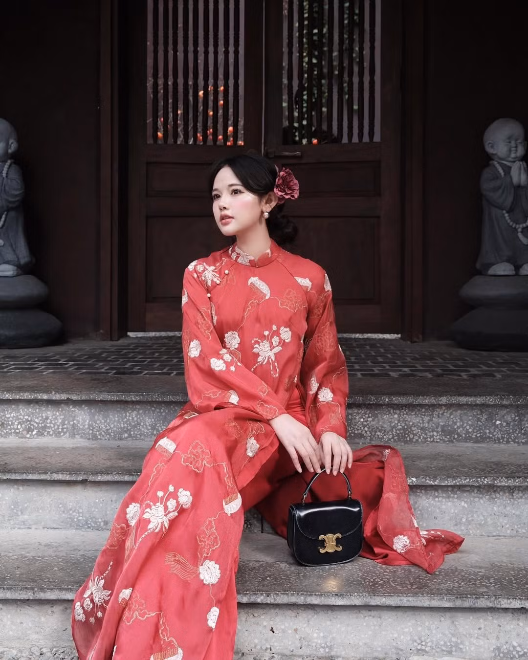 Cũng diện sắc áo dài đỏ xuống phố để chụp ảnh Tết sớm, hot girl Thư Thỏ lựa chọn cho mình một sắc đỏ nhã nhặn hơn, với những họa tiết được thêu lên vải tinh tế, ấn tượng.