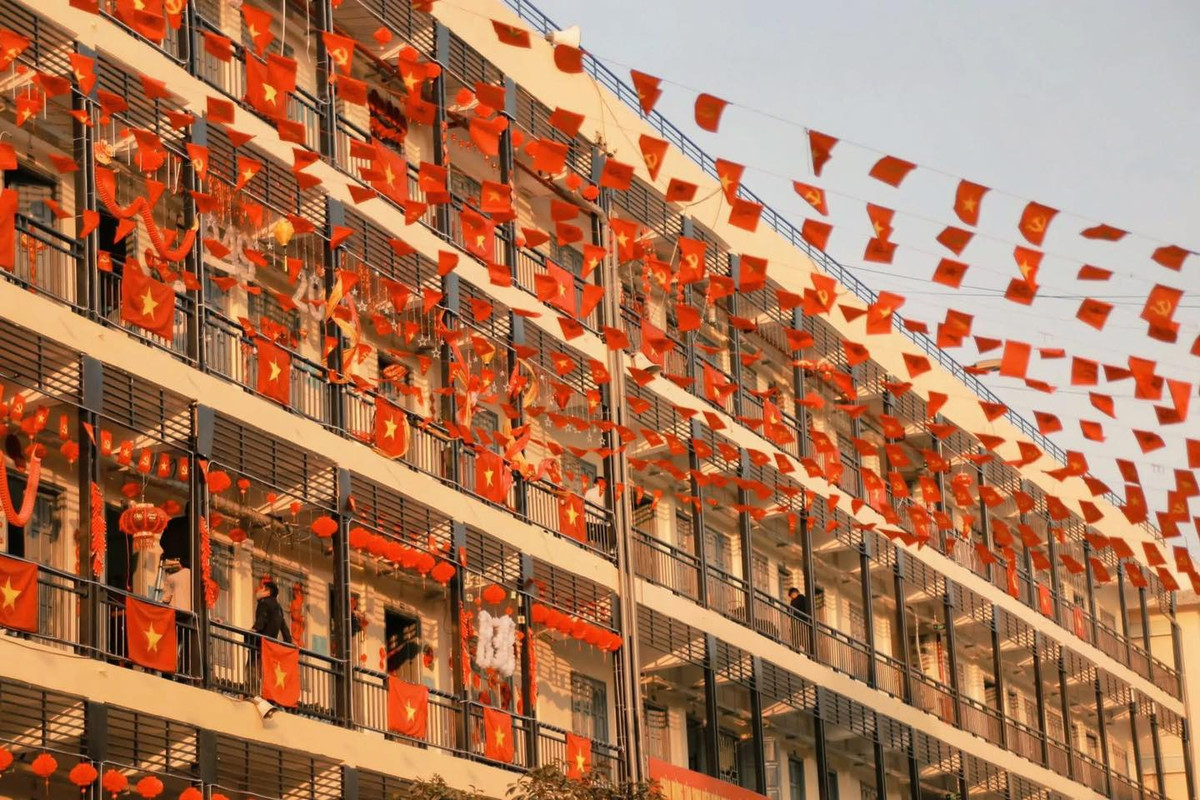 Hàng trăm lá cờ Tổ quốc và cờ Đảng được treo trên khoảng không trước ký túc xá, tạo thành một biển cờ đỏ sao vàng tuyệt đẹp. Ánh nắng buổi sớm chiếu rọi vào những lá cờ, khiến chúng trở nên lung linh hơn bao giờ hết.