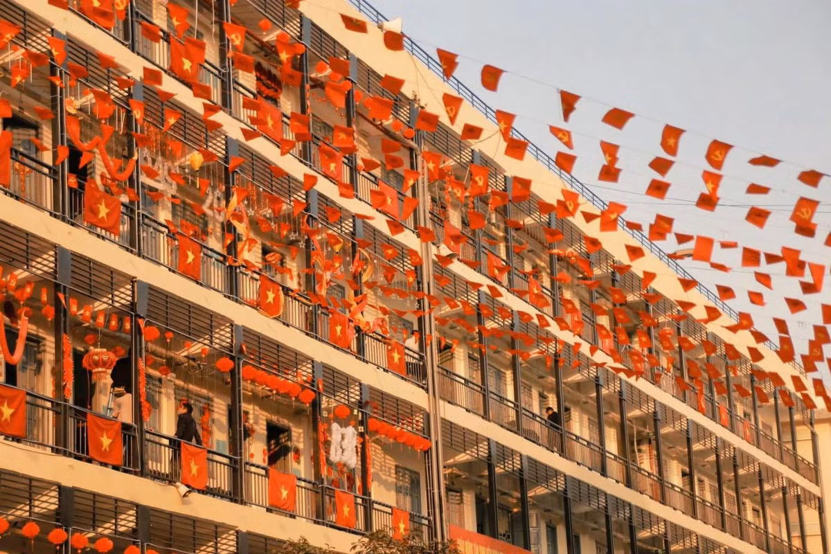 Hàng trăm lá cờ Tổ quốc và cờ Đảng được treo trên khoảng không trước ký túc xá, tạo thành một biển cờ đỏ sao vàng tuyệt đẹp. Ánh nắng buổi sớm chiếu rọi vào những lá cờ, khiến chúng trở nên lung linh hơn bao giờ hết.