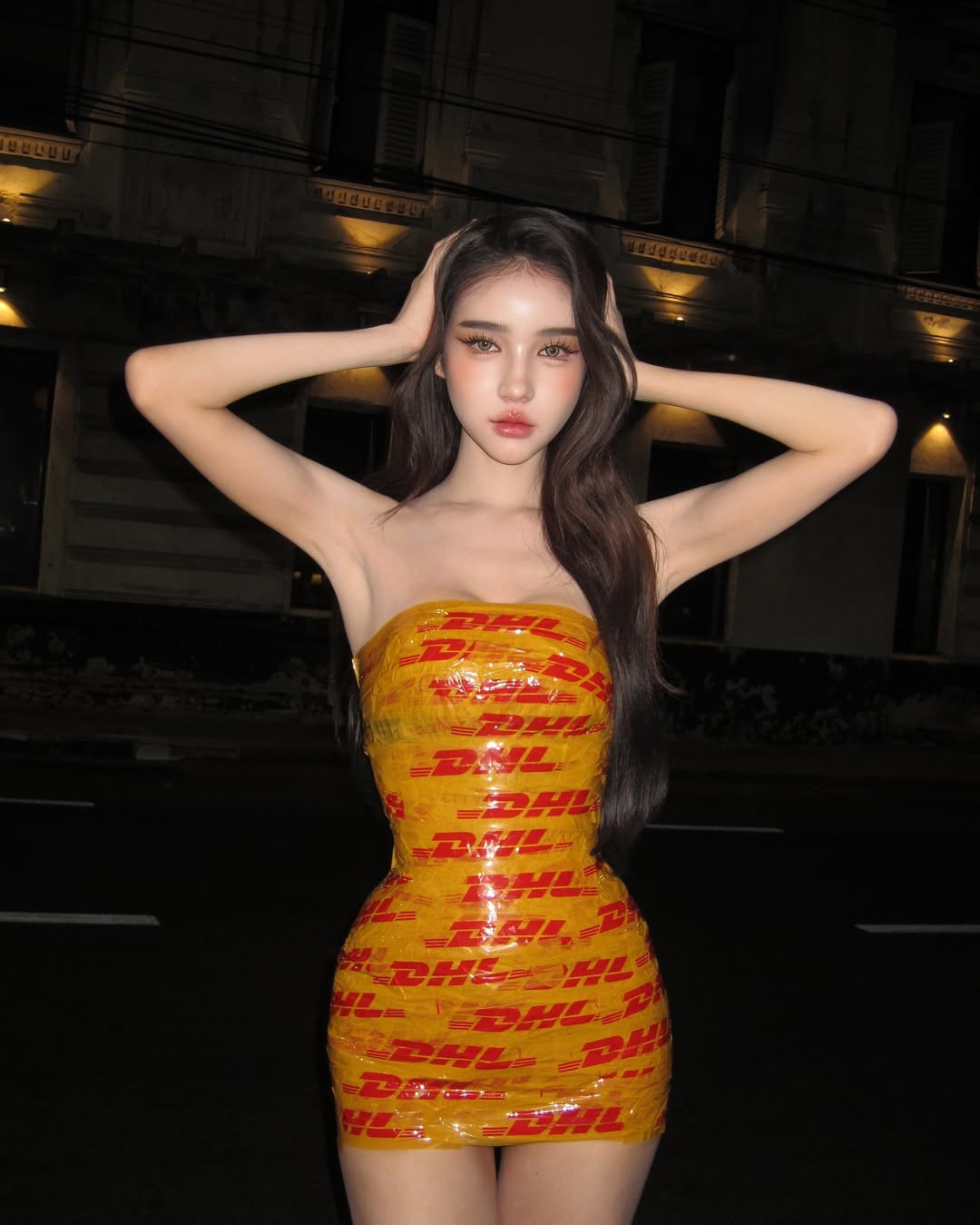 Trào lưu làm trang phục quấn băng keo này bắt nguồn từ siêu mẫu Gigi Hadid. Tại show thời trang Xuân/Hè 2025 của thương hiệu Vetements thuộc khuôn khổ Tuần lễ thời trang Paris, Gigi mặc váy quây được tạo thành từ dải băng keo vàng chữ đỏ của công ty vận tải DHL, khoe trọn vẹn vóc dáng mà chẳng cần phải hở bạo.