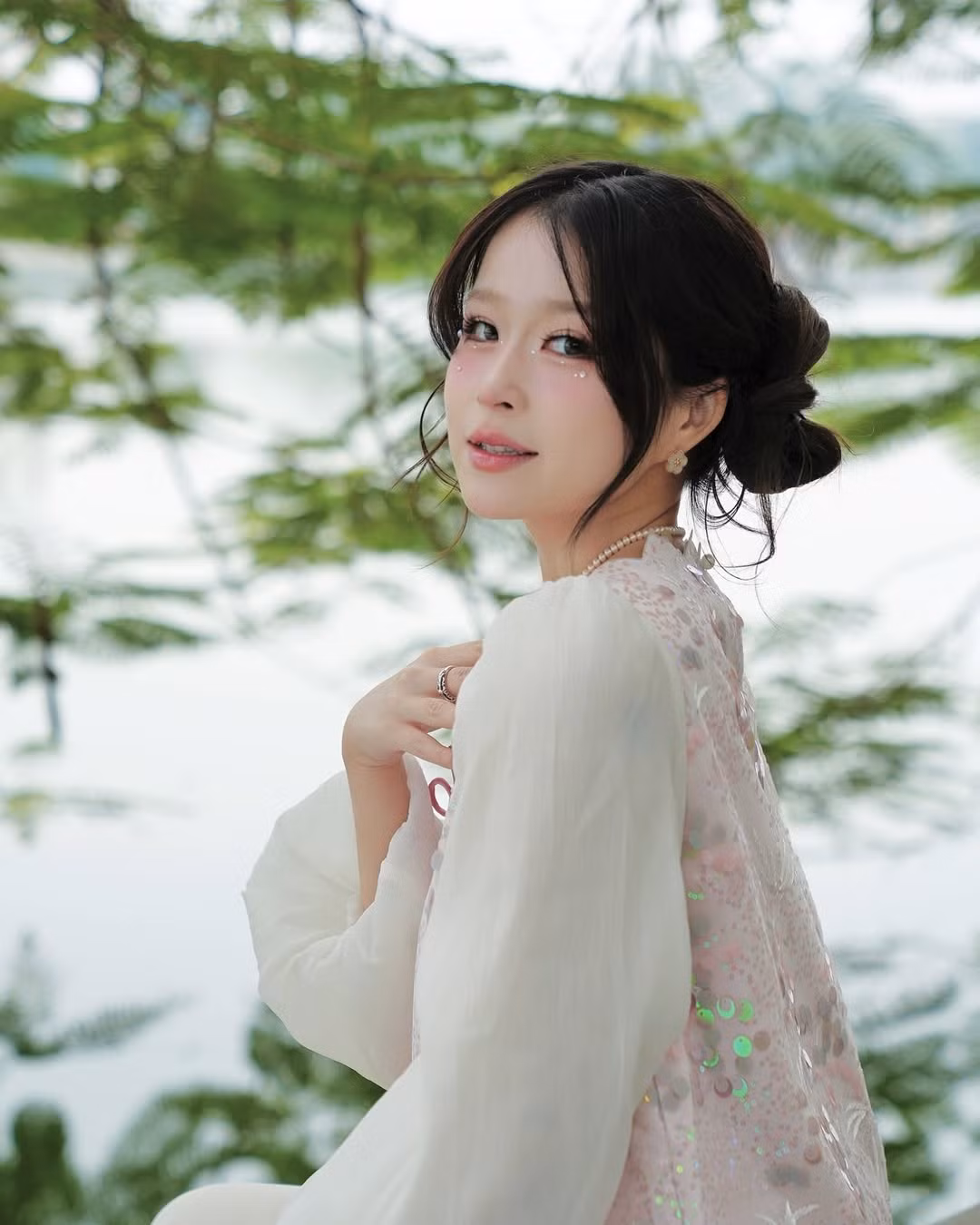 Khung cảnh nước hồ xanh biếc với tháp Rùa cổ kính xa xa, cùng những cành cây rủ xuống mặt hồ càng tôn lên vẻ đẹp dịu dàng, nữ tính của Chao.