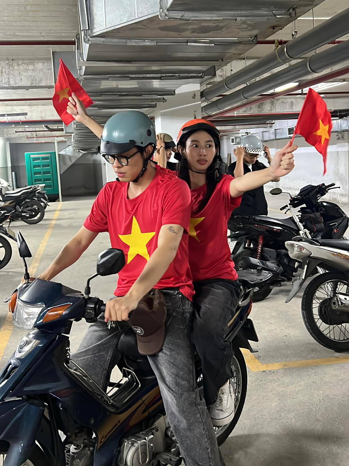 Không phải hình ảnh hào nhoáng khi xuất hiện trên sân khấu, HURRYKNG và Thùy Tiên mặc áo cờ đỏ sao vàng, quần jean đơn giản để cùng hòa vào dòng người.