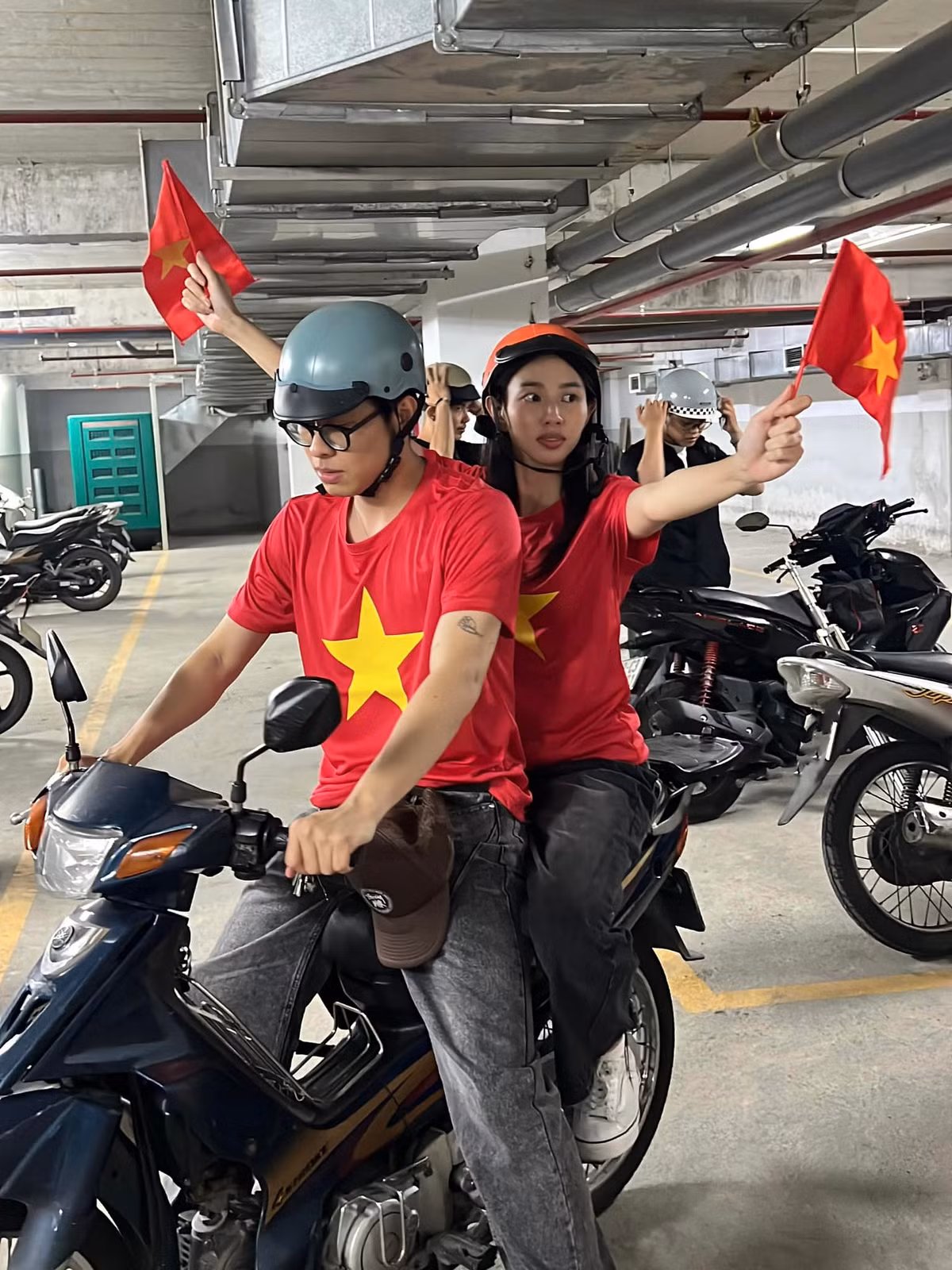 Không phải hình ảnh hào nhoáng khi xuất hiện trên sân khấu, HURRYKNG và Thùy Tiên mặc áo cờ đỏ sao vàng, quần jean đơn giản để cùng hòa vào dòng người.