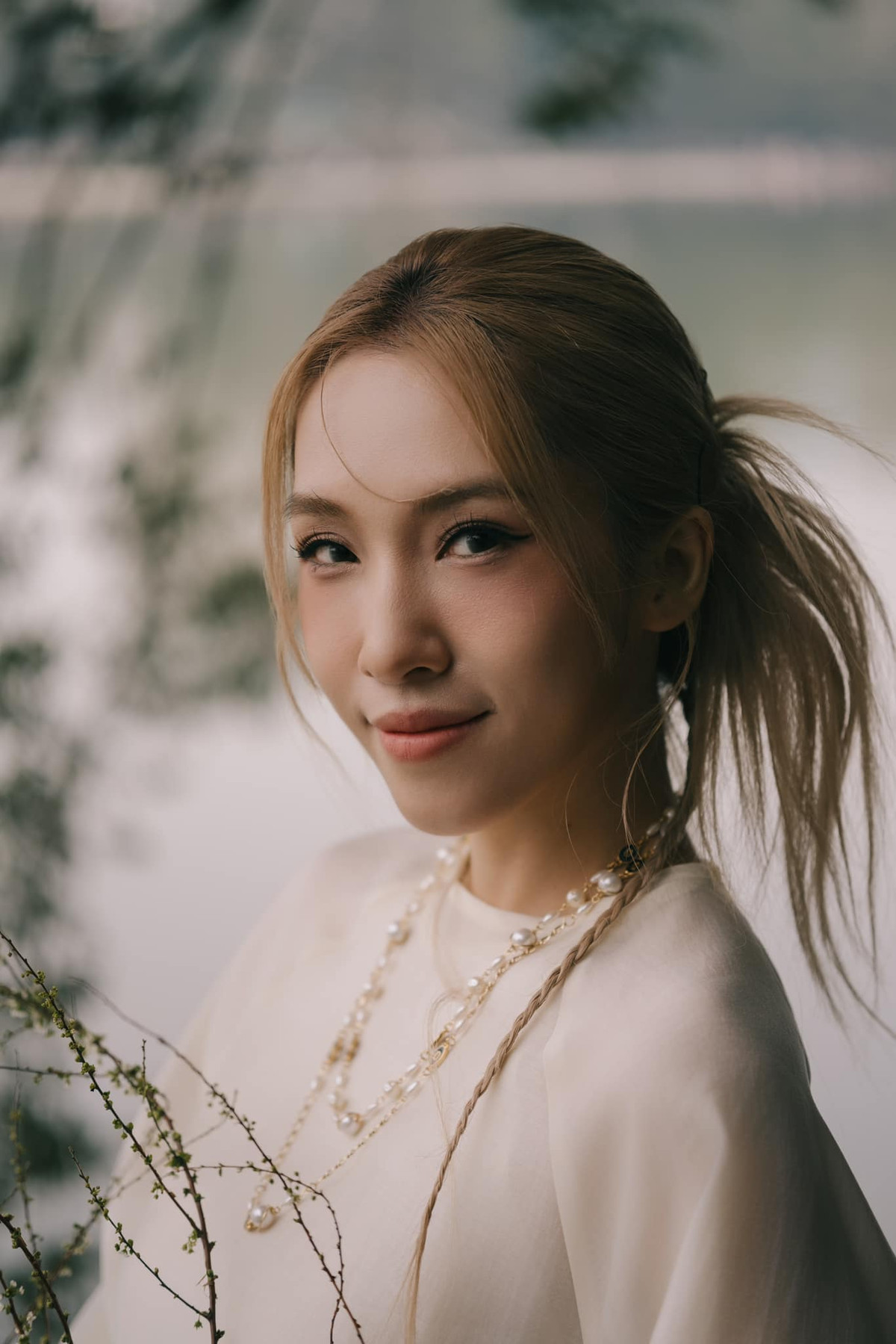 Tà áo dài trắng tinh khôi phom suông truyền thống càng tôn lên vẻ đẹp dịu dàng, kiêu sa của cô.