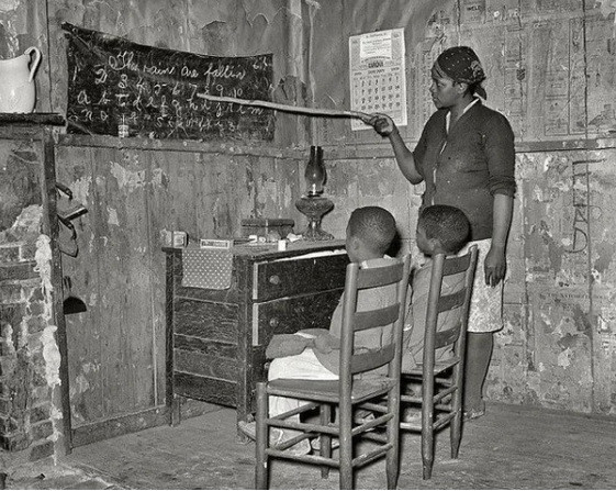 Một phụ nữ da màu ở Transylvania, Louisiana, Mỹ dạy học cho hai con tại nhà năm 1937.