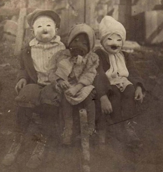 Ba đứa trẻ đeo mặt nạ hóa trang đáng sợ trong lễ hội Halloween năm 1900.