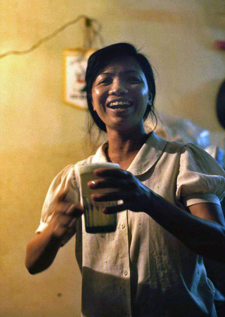 Một phụ nữ mang cốc bia cho khách.