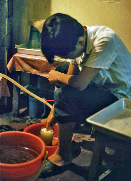 Chủ quán rót bia vào cốc cho khách từ bom bia lớn.