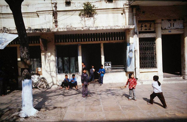 Một nhóm trẻ em chơi đùa trước nhà.