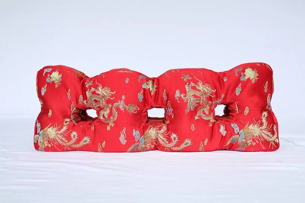 Một trong những vật phẩm mà bà yêu thích và sử dụng hàng ngày là chiếc gối ngủ đặc biệt. Chiếc gối này được làm từ hoa cúc phơi khô và thảo dược quý hiếm, với lõi ruột là hoa cúc giúp thư giãn và kích thích tuần hoàn máu. Chiếc gối không chỉ thơm mát mà còn có các lớp vải đỏ, vàng, giấy dầu và lụa.