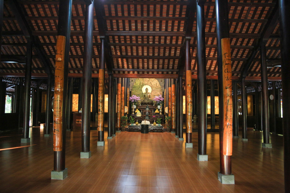 Khu chánh điện thờ tượng phật Thích Ca và nhiều vị Thánh Tăng. Phía sau có bức thư pháp lớn và hai bình hoa trang trí bắt mắt.