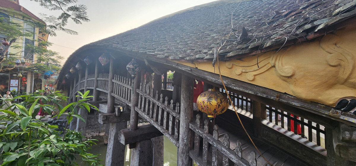 Cầu ngói chợ Lương còn gây ấn tượng đặc biệt với hình tượng cuốn thư trên hành trụ, dưới là cửa cuốn. Cuốn thư tạo dáng mềm, đề 4 chữ “Quần Phương xã kiều” (tức cầu xã Quần Phương).