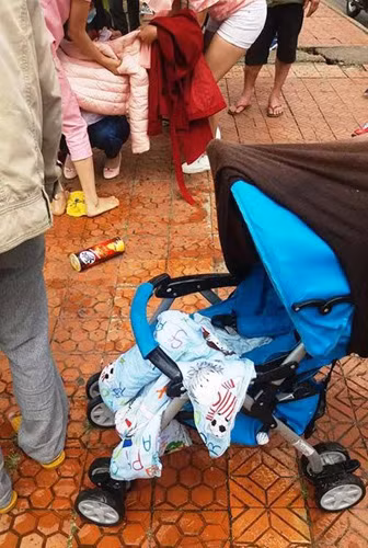 Cháu bé và chiếc xe khi vừa được vớt lên khỏi hồ nước