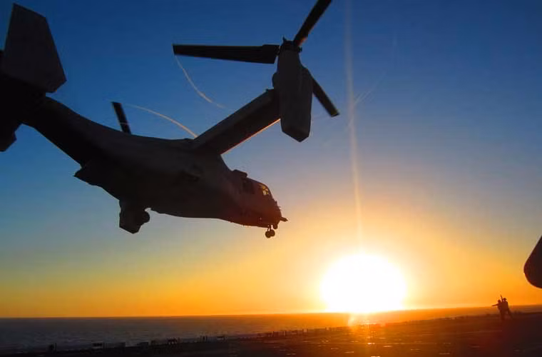 Bức ảnh quân sự đẹp trong tuần – máy bay cánh quạt xoay MV-22 Osprey hạ cánh xuống boong tàu đổ bộ USS America (LHA 6) trong thời điểm mặt trời đang lặn dần.