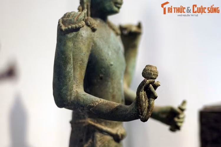 Tượng có bốn tay, hai tay trước cầm nụ sen và bình nước cam lồ. Hai tay sau cầm tràng hạt và quyển sách.