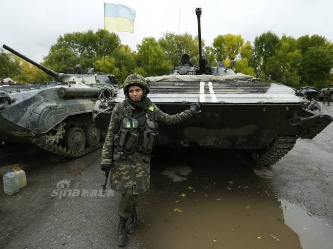 Dịu dàng khoác súng tạo dáng bên... xe thiết giáp. Nguồn ảnh: Sina.