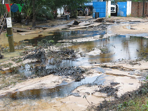 Nước lũ chảy xiết làm vỡ nhiều thùng phuy khiến dầu nhớt chảy tràn vào nhiều nhà dân ở khu vực này. Nguồn ảnh:VOV.