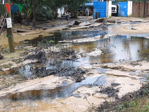 Nước lũ chảy xiết làm vỡ nhiều thùng phuy khiến dầu nhớt chảy tràn vào nhiều nhà dân ở khu vực này. Nguồn ảnh:VOV.