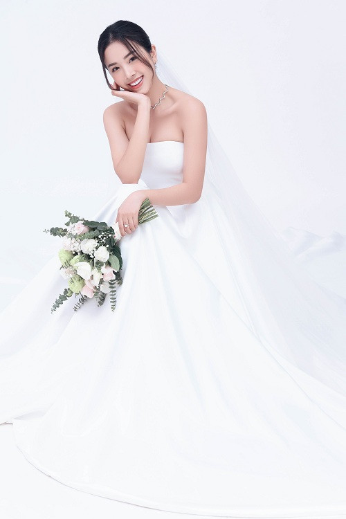 Kiểu dáng cúp ngực cùng thân váy xòe, kết hợp layout tóc nhẹ nhàng giúp tôn lên nét dịu dàng, nữ tính của nàng á hậu.