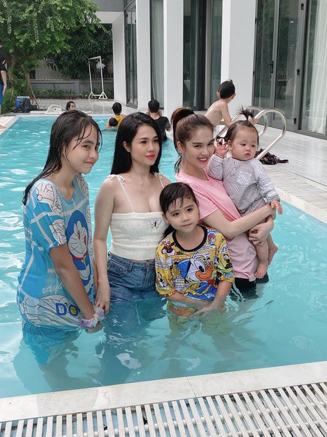 Đứng cùng chị gái ở hồ bơi, Ngọc Trinh ăn mặc khá thoải mái. Cô cột tóc gọn gàng để vừa chơi vừa trông cháu. Có lẽ vì vậy mà chân dài sinh năm 1989 nhạt nhòa hơn chị.