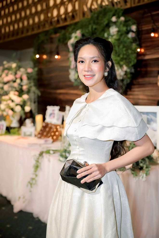 Minh Hà diện đầm trắng thanh lịch. Bà xã Lý Hải cho biết để kịp về dự tiệc cưới cháu, hai vợ chồng cô phải tạm dừng việc cứu trợ ở miền Trung. Lý Hải - Minh Hà vừa đáp chuyến bay từ Đà Nẵng vào TP.HCM.