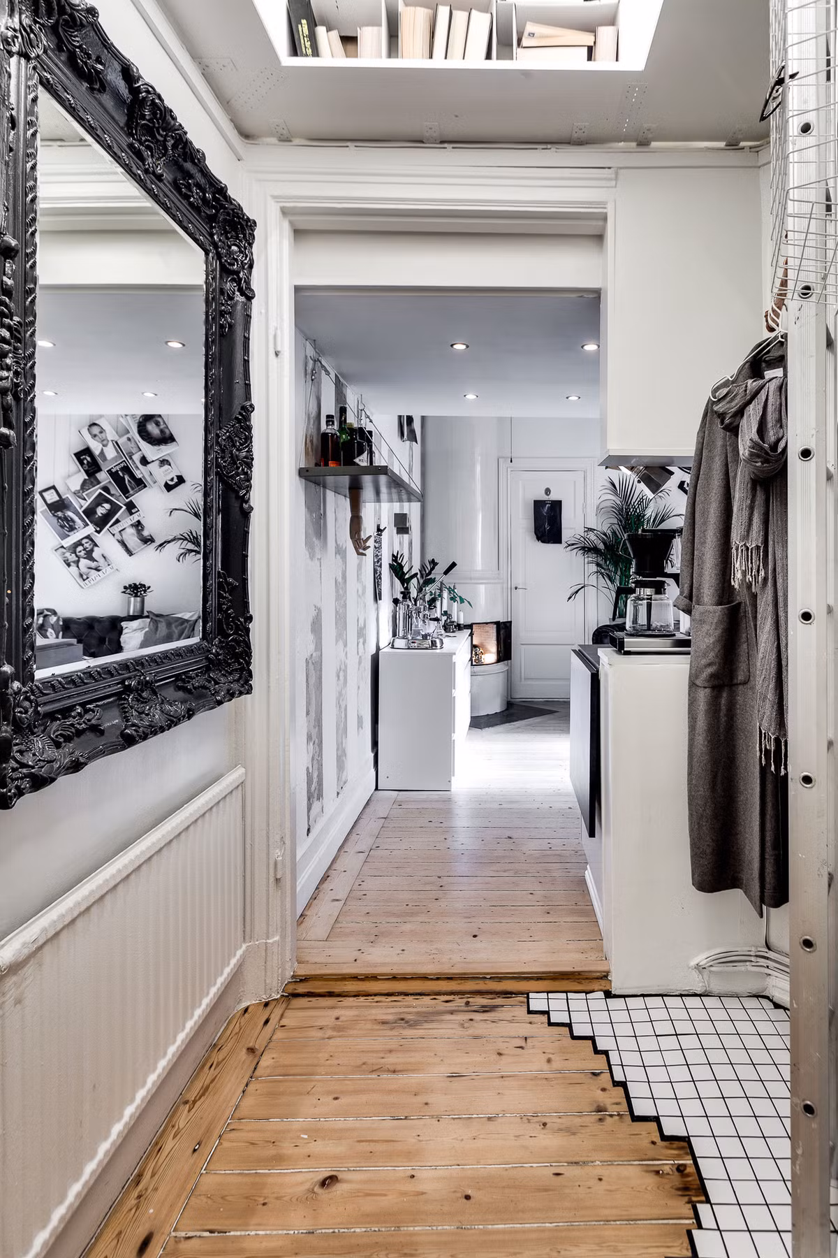 Hành lang dẫn ra cửa ra vào khá nhỏ, do vậy chủ nhà đã sử dụng gương để tạo nên độ sâu về không gian. Khung gương màu đen được điêu khắc tỉ mỉ nổi bật trên nền tường màu trắng. Còn trên gác xép rất đơn giản với nệm và chăn để làm chỗ ngủ. Đầu giường có hai bóng đèn đơn giản giúp thắp sáng khi cần.