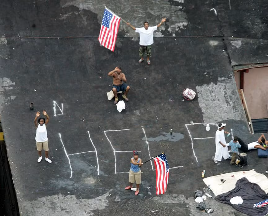 Một số người dân Mỹ vẫy cờ với hy vọng sẽ được giải cứu và hỗ trợ sau khi cơn bão Katrina quét qua. Cơn bão Katrina đã đổ bộ vào Mỹ ngày 29/8/2005 và gây hậu quả kinh hoàng tại 5 bang ven Vịnh Mexico. Bang Louisiana là nơi chịu ảnh hưởng nặng nề nhất, với khoảng 1.300 người chết.