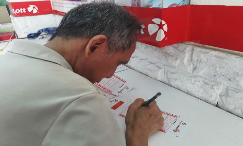 Nhiều người cao tuổi tỉ mỉ lựa chọn từng con số. Ảnh: Thái Nguyễn.
