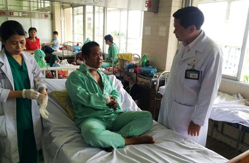 Anh Quang (áo xanh, nằm trên giường) vừa được các bác sĩ BV Chợ Rẫy cứu sống. Nạn nhân vẫn còn ám ảnh giây phút trung tá Campuchia nổ súng giết người.