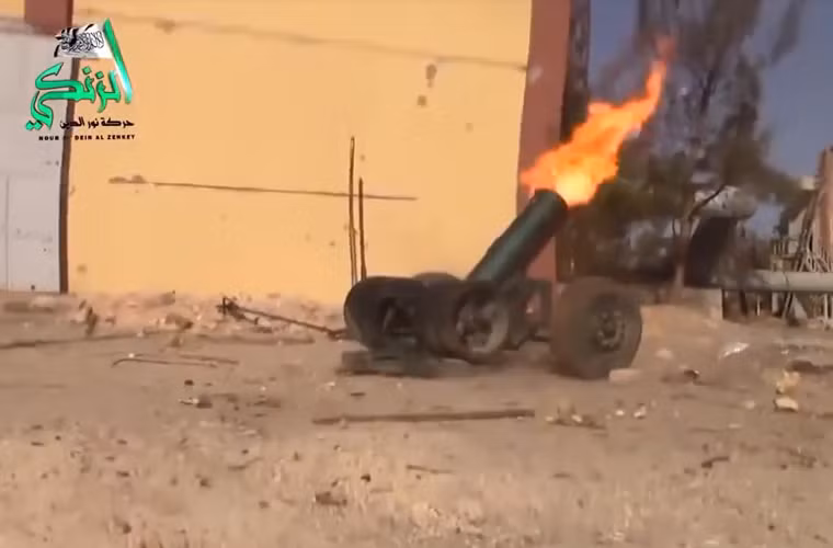 Đại bác cỡ lớn phụt lửa sau khi khai hỏa trên đường phố Aleppo.