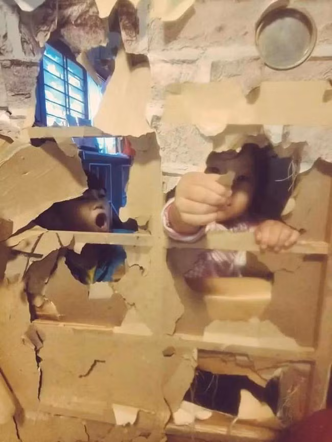 2 "tiểu yêu" nghịch ngợm phá nát tấm cửa giấy rồi.