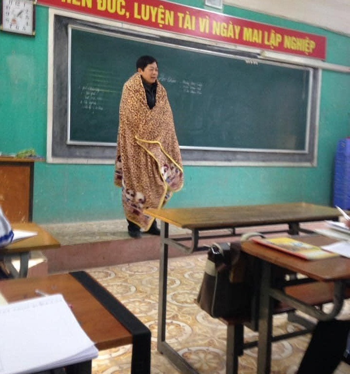 Theo đó, bức ảnh gây chú ý về thầy giáo đang đứng trên bục giảng nhưng trên người thầy lại khoác tấm chăn lớn phủ kín từ vai đến chân. Hình ảnh này đã nhanh chóng được lan truyền, nhiều ý kiến đều cho rằng vị thầy giáo này rất gần gũi và dễ thương với chiếc chăn trùm kín như vậy sẽ giúp tiết học trở nên ấm áp hơn.
