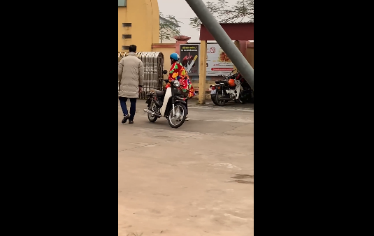 Theo đoạn clip ghi lại, nam sinh này đã choàng hẳn chiếc chăn len hoa lá đỏ rực ngay từ nhà và cứ thế chạy xe đến trường. Nhìn cảnh tượng này, không chỉ các bạn cùng lớp mà ngay cả thầy cô giáo cũng phải "bó tay".